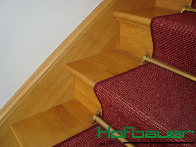 Neue Massivholztreppe in hellem Design, ergänzt durch einen roten Teppich