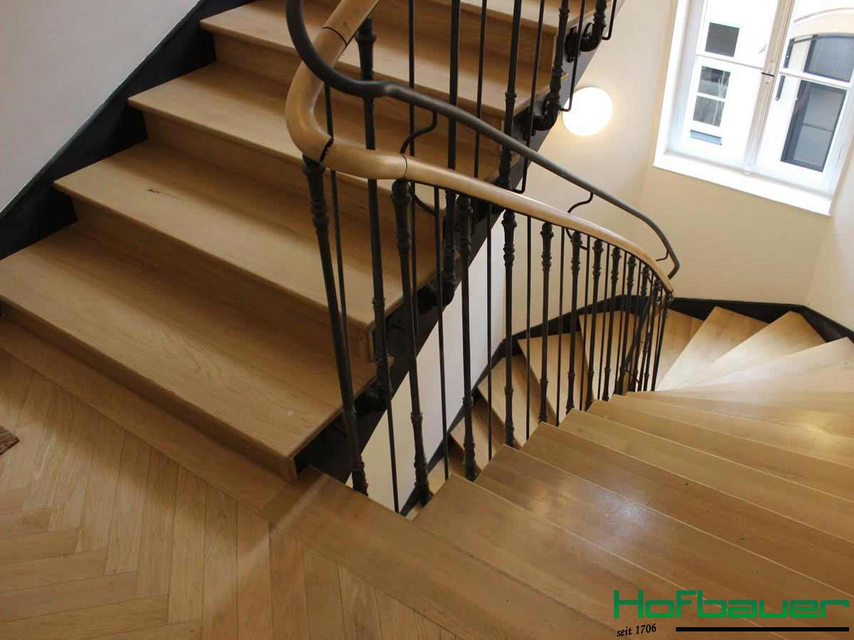Neuer Hausflur im minimalistischen Stil: Helle Holztreppen kombiniert mit einem Treppengeländer aus schwarzen, dünnen Metallstäben