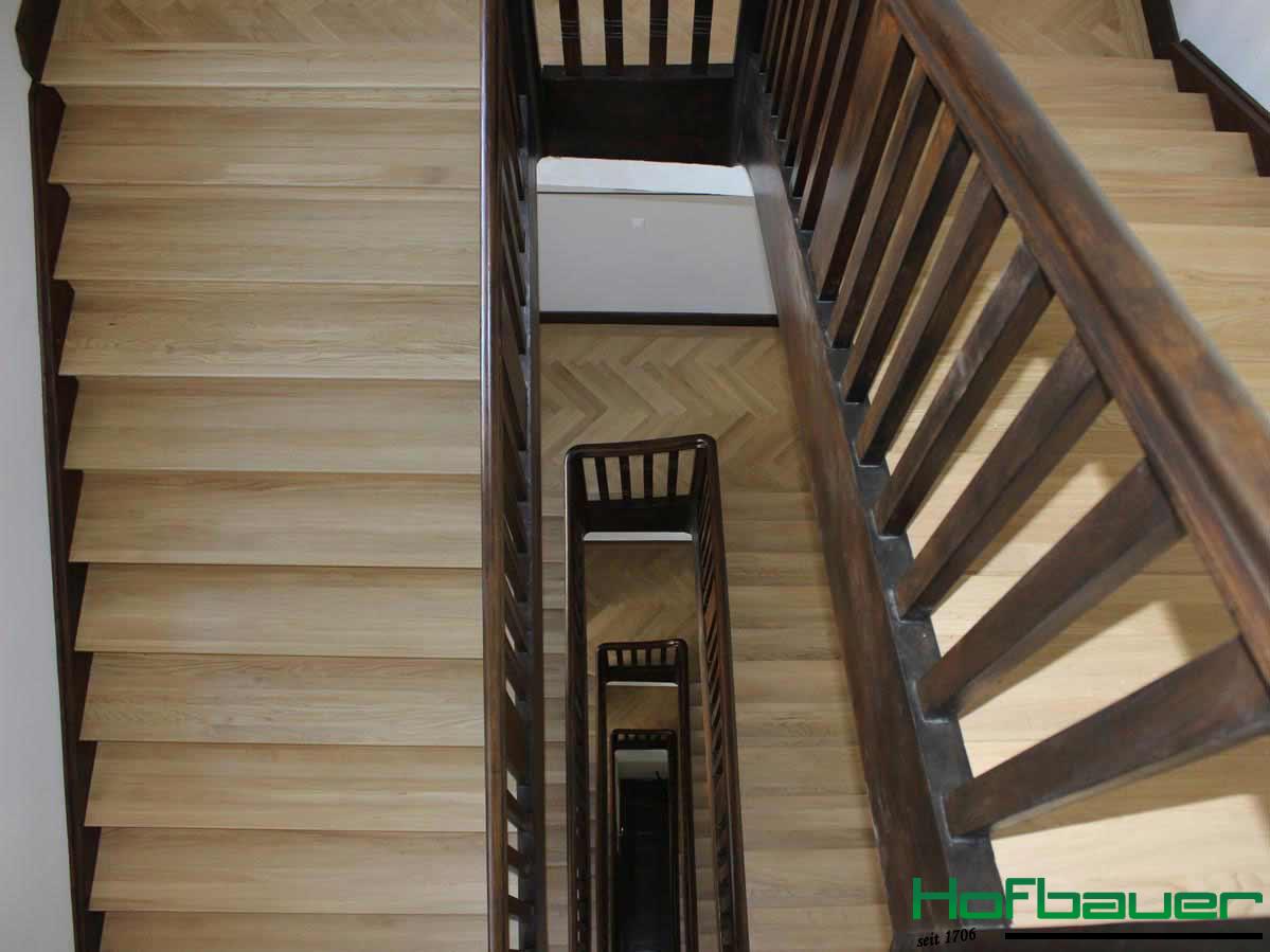 Neuer Hausflur aus der Vogelperspektive: Das Treppenhaus präsentiert sich in einer Kombination aus hellen Holztreppen und einem Treppengeländer aus dunklem Holz