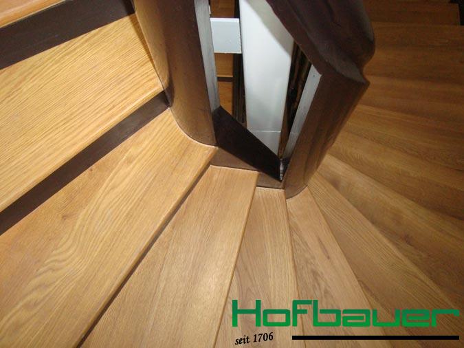 Wendeltreppe in der Nahaufnahme: Die Trittstufen präsentieren sich in einem hellem Massivholz und sind mit einer Setzstufe aus dunklem Holz kombiniert