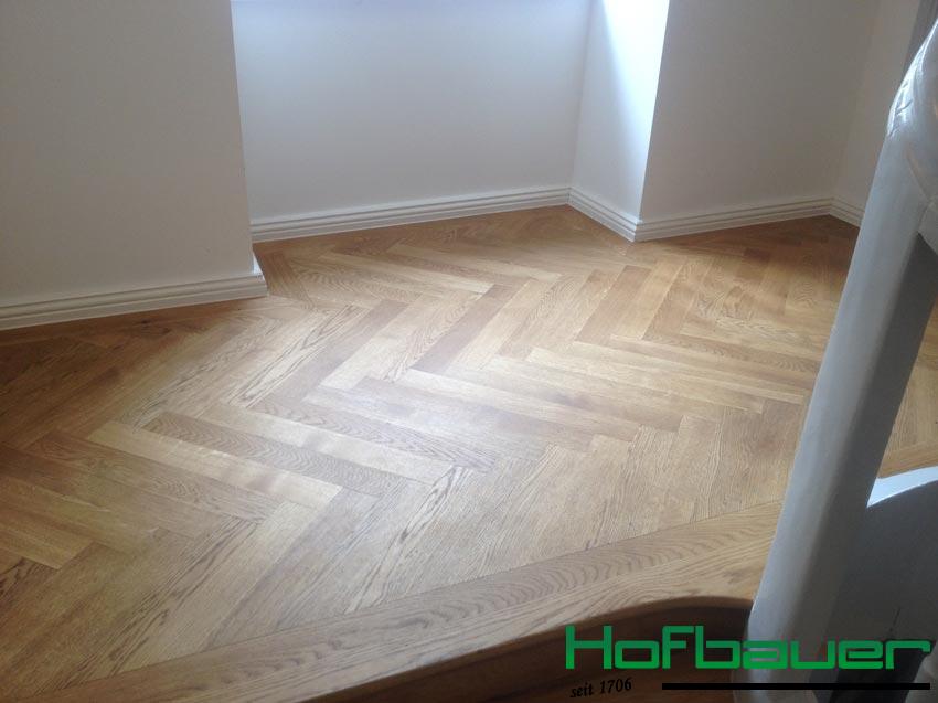 Treppenabsatz aus hellem Holz in Fischgrätenoptik