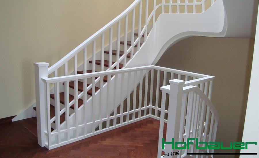 Weiße Wendeltreppe aus Holz mit dunklen Trittflächen und weißem Treppengeländer