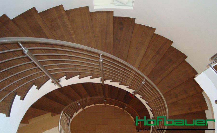 Moderne Wendeltreppe in dunkelem Holz inklusive silbernen Treppengeländer aus Metall