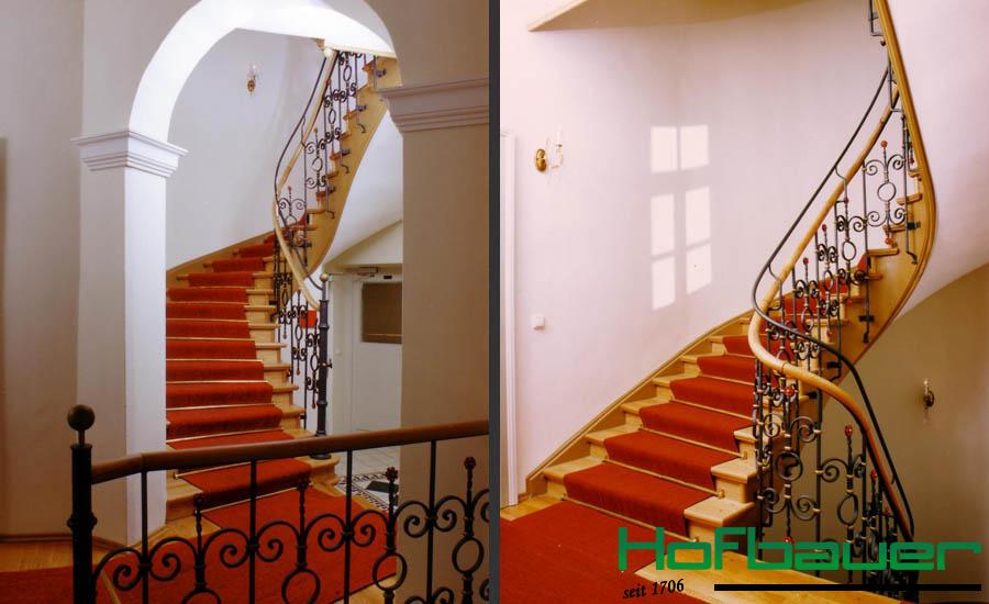 Massivholztreppen im Jugendstil in ähnlicher Perspektive: Eine helle Holztreppe mit rotem Teppich sowie einem Treppengeländer im klassischen Jugendstil